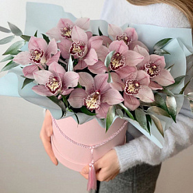 Розовые орхидеи с зеленью в шляпной коробке