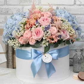 Композиция из разноцветных роз в большой голубой шляпной коробке